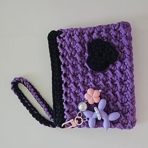 Crocheted wristlet clutch in purple and black.
